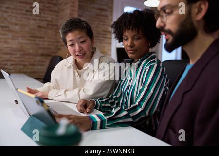 Marketing team working on project using laptop and tablet Stock Photo