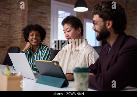 Marketing team working together on devices in modern office Stock Photo