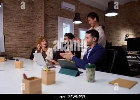 Happy business team clapping, celebrating success in modern office Stock Photo