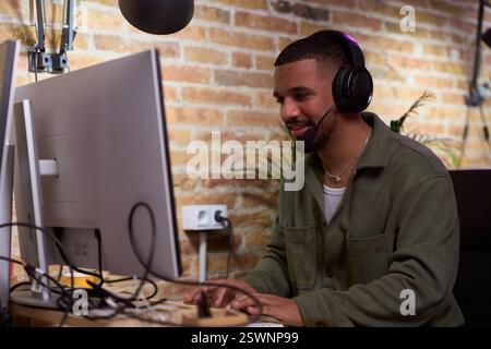 Focused young businessman working from home using computer and headset Stock Photo