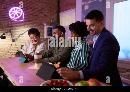 Coworkers using digital tablets, working late in modern office Stock Photo