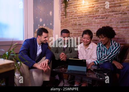 Startup team analyzing data on tablet in cozy office space Stock Photo