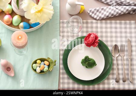 Easter table setting with flowers, painted eggs and Easter bunny Stock Photo