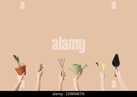 Female hands with gardening tools and plant on beige background Stock Photo