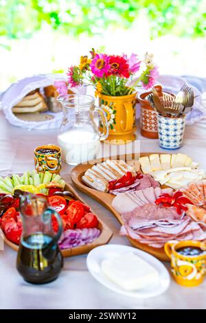 A vibrant table setting featuring breakfast dishes, fresh flowers, and colorful decorations. Stock Photo