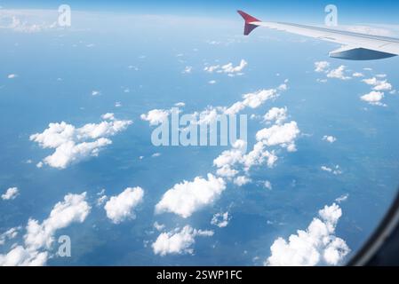 View from an airplane window over a stunning expanse of fluffy white clouds Stock Photo