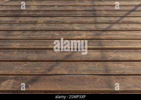 Close-up view of a weathered wooden boardwalk with traces of sand, creating a textured background reminiscent of a seaside promenade in marsa alam, eg Stock Photo