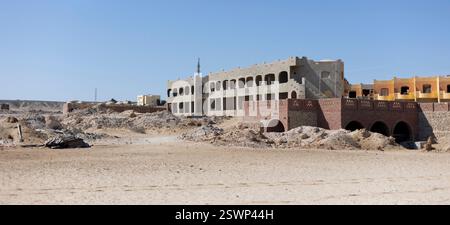 Construction site of a tourist resort in marsa alam, egypt, showing unfinished buildings and piles of rubble under a clear blue sky Stock Photo