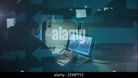 Analyzing financial data on laptop, person working late in office, image overlay Stock Photo