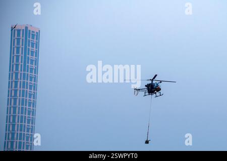 Helicopter is flying over isolated blue sky in a city Stock Photo