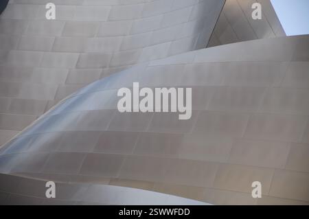 Modern architecture with curving metallic surfaces reflecting sunlight Stock Photo