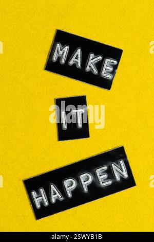 Make It Happen words on black sticky notes isolated on yellow background Stock Photo