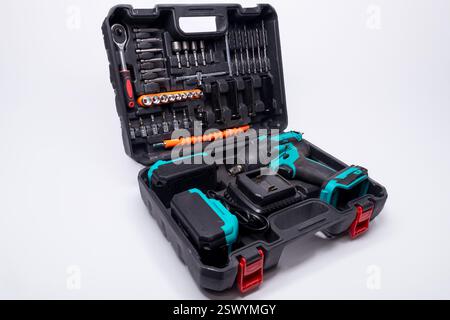 Cordless impact wrench, batteries, charger, and various tools organized in a toolbox, ready for maintenance or diy projects Stock Photo
