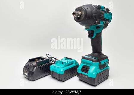 Professional impact wrench with battery and charger isolated on transparent background, essential tools for mechanics and construction workers Stock Photo