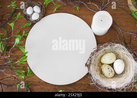 Easter eggs in decorative straw nest and round epmpty cardboard, blank circle sign with copy space on brown wooden background. Festive holiday atmosph Stock Photo
