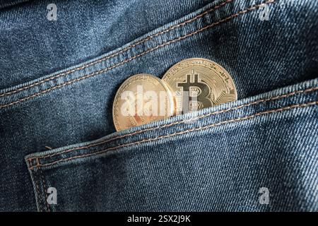 Two Bitcoin physical coins inside a blue jeans pocket Stock Photo