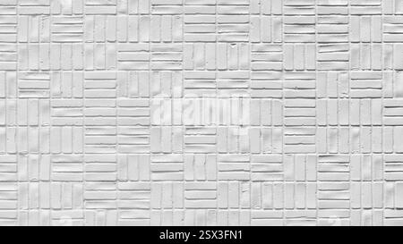 wall is made of white bricks and has a unique pattern of squares. The bricks are arranged in a way that creates a visually interesting design. The wal Stock Photo
