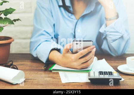 using smart phone showing blank white screen in woman hand on desk office Stock Photo