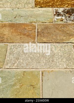 Close-up of a stone wall highlighting the variety of textures and colors in each block, forming a visually appealing pattern Stock Photo