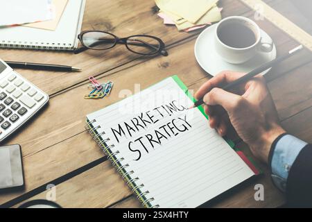 Young businessman written  marketing strategy text on notebook Stock Photo