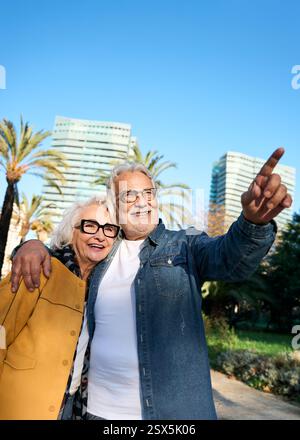 Senior couple pointing while visiting Barcelona city during vacation Stock Photo