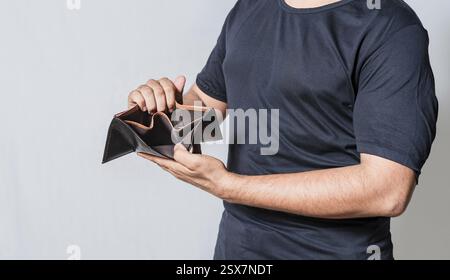 Hands of bankrupt person showing an empty wallet isolated. Man's hands in financial crisis showing wallet Stock Photo