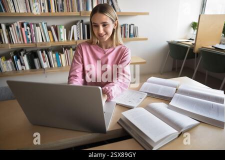 Student girl engaged in academic workflow using laptop Stock Photo