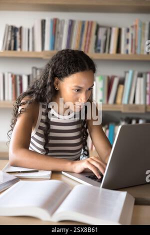 Focused African girl studying online using laptop Stock Photo
