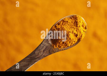 Turmeric powder on a spoon, top view Stock Photo