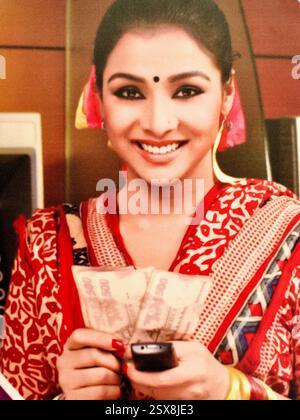 Woman displays Bangladeshi currency with mobile phone, highlighting easy cash access via Dutch-Bangla Bank’s Rocket mobile banking platform. Stock Photo