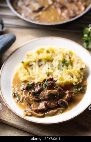 Roasted Pork Neck with mashed potatoes and mushroom sauce on a plate. Stock Photo