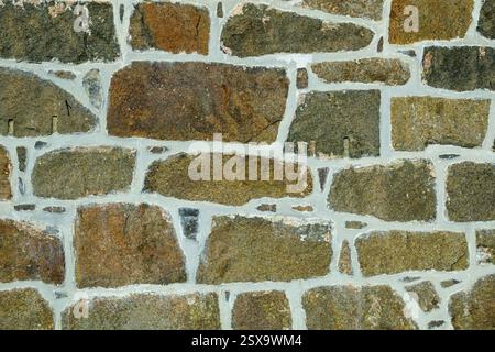 This structure features a rustic stone wall showcasing a blend of earthy tones and textures. The stones are arranged in a unique pattern, enhancing th Stock Photo