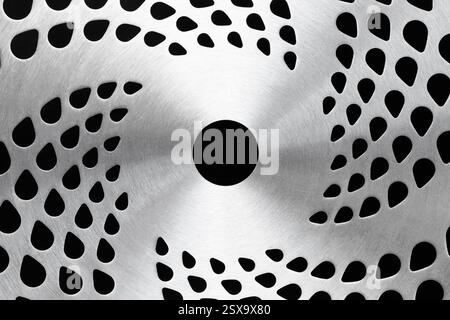 Metal disk with holes arranged in a spiral. Abstract technological background Stock Photo