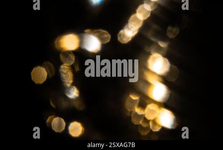 Golden lights bokeh on a black background. Abstract lights. Stock Photo