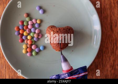 chocolate icing in a bag to decorate homemade Easter muffins Stock Photo