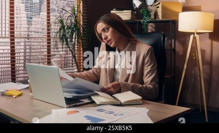 Overwhelmed Caucasian entrepreneur business woman girl female businesswoman worker lady manager secretary multitasking drinking coffee work laptop Stock Photo