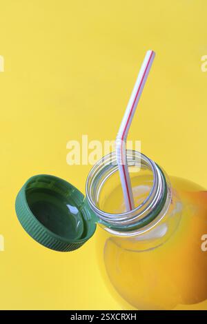 Orange juice in plastic bottle with cap and straw Stock Photo