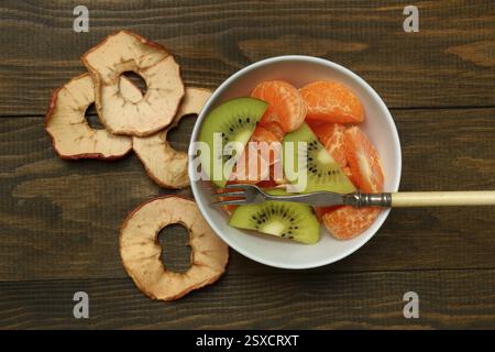 Clementine pieces and kiwi slices in peel, dried apple slices Stock Photo