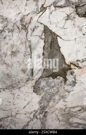 Marble surface with a prominent crack, displaying gray and white textures and pattern, stone, natural stone, stone structure Stock Photo