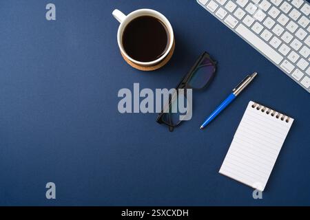 Workspace with keyboard, office supplies, pen and coffee cup. Flat lay, top view blue office desk Stock Photo