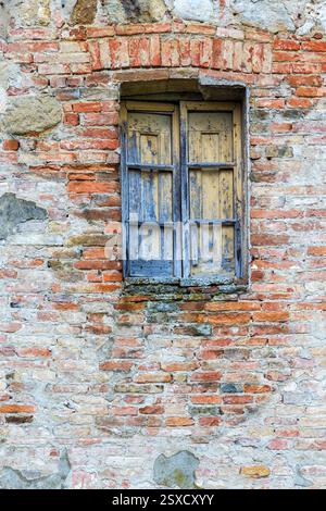 Old weathered window on a brick wall Stock Photo