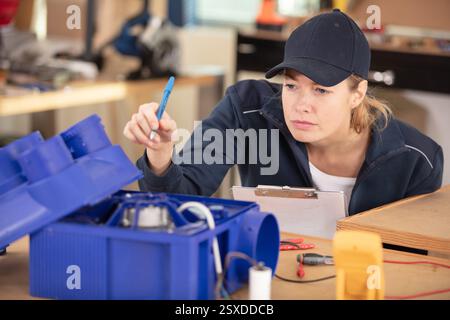 a woman worker soldering circuits at the factory Stock Photo