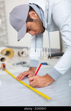 a young man holds a level for measuring floor Stock Photo