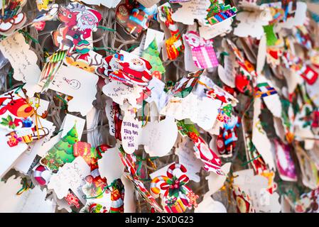 Malaga, Spain 27 December 2024 notes with christmas and new year wishes (like 'cherish the moment') left on a christmas tree Stock Photo