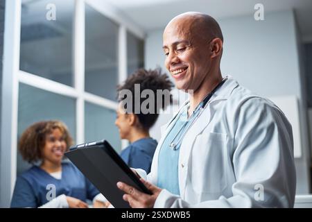 Smiling Healthcare Professional Using a Digital Tablet in a Medical Office Stock Photo
