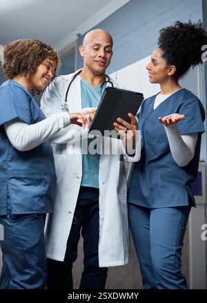 Healthcare Team Discussing Patient Data Using Digital Tablet in Bright Clinic Setting Stock Photo