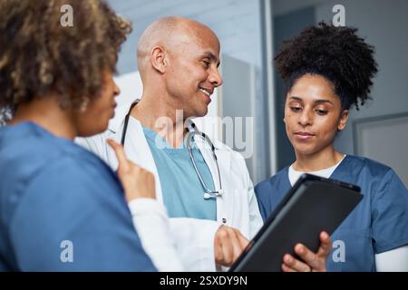 Healthcare Team Collaborates Using Digital Tablet in Modern Medical Setting Stock Photo