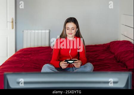 Young woman playing video games with headphones and controller Stock Photo