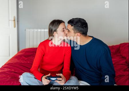 Young couple kissing while playing video games Stock Photo
