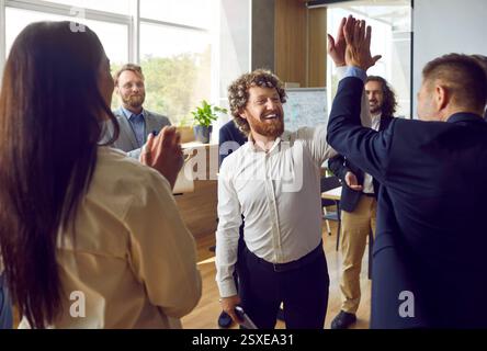 Group of corporate employees having fun during teamwork training with professional coach Stock Photo